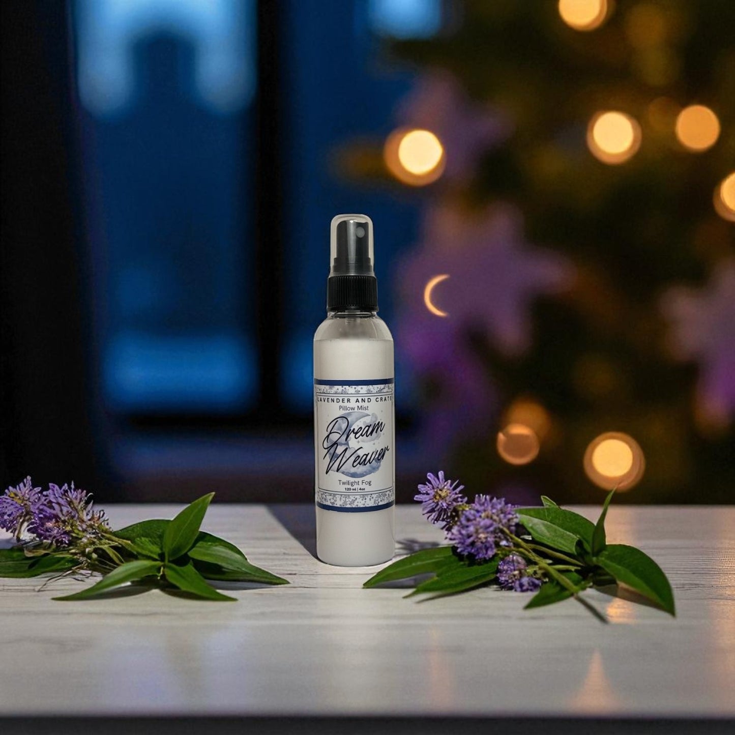 Spray bottle labeled 'Dream Weaver' with purple flowers on a table, blurred lights in the background